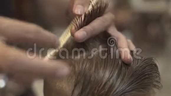 理发师用理发剪梳理湿头发在男性沙龙近距离儿童理发视频的预览图