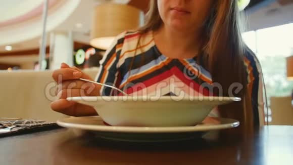 一盘食物小女孩在咖啡馆里用勺子吃汤近距离射击视频的预览图