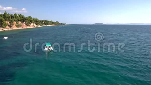 在希腊哈尔基迪基航行到大海的小型充气船的鸟瞰图用无人驾驶飞机前进视频的预览图