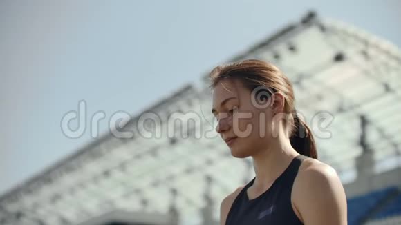 一幅美丽女子在体育场看台上奔跑的时光流逝画像集中了深深的呼吸和视频的预览图