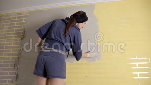 一个女孩拿着一把油灰刀乱扔糊糊一种抹一层抹子和腻子膏的方法视频的预览图