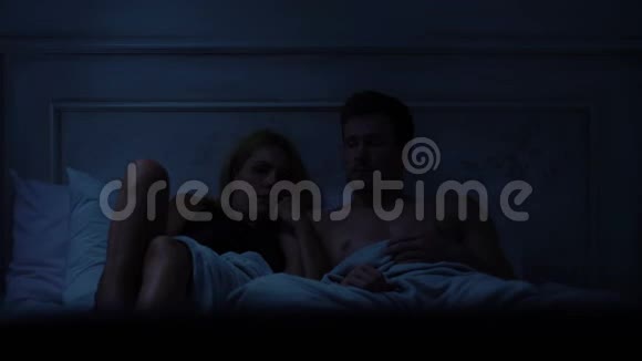 年轻夫妇看恐怖电影男的可怕的女士都玩得很开心视频的预览图