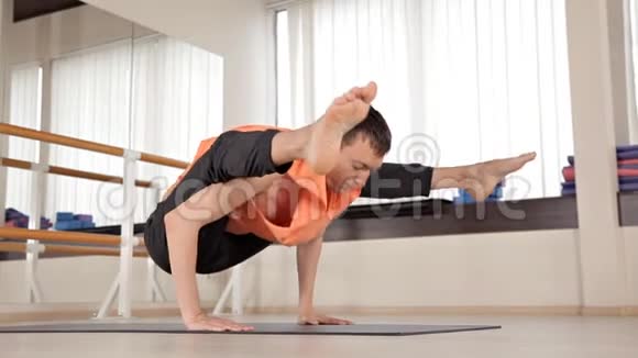 年轻的运动员坐在带镜子的健身房蓝色垫子上的瑜伽姿势瑜伽运动放松灵活视频的预览图