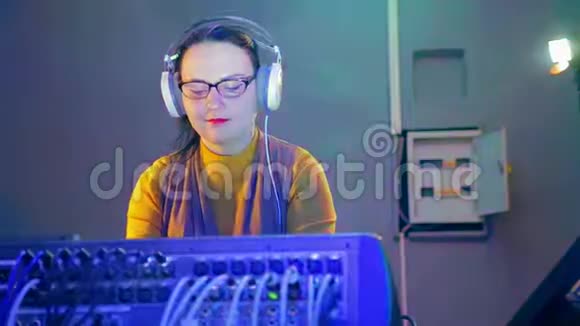 收音机里戴着耳机和眼镜的女DJ在混合控制台拿着迪斯科视频的预览图