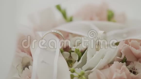 有结婚戒指的婚礼花束放在桌子上视频的预览图