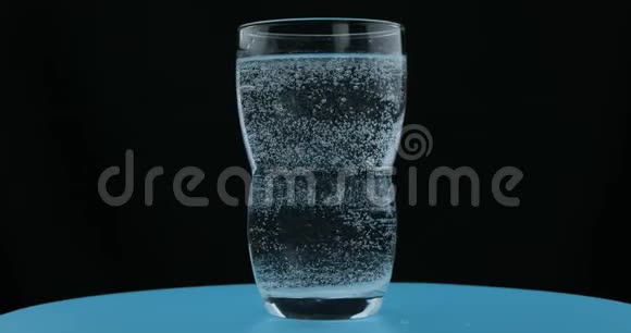 矿泉水中的气泡黑色背景玻璃中的苏打水视频的预览图
