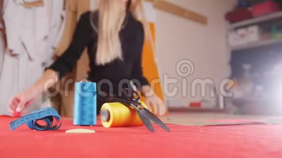 缝纫厂的年轻妇女用剪刀剪布缝纫线在焦点静态射击视频的预览图
