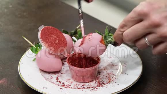用粉红色巧克力覆盖的成熟草莓涂上粉红色闪亮的食物漆视频的预览图