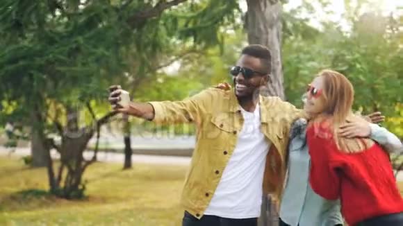 快乐的朋友多种族的团体正在自拍戴着太阳镜拥抱站在公园里非洲帅哥视频的预览图