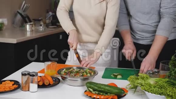 一对夫妇在厨房准备晚餐切蔬菜做沙拉视频的预览图