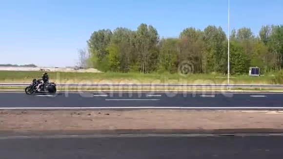 两个骑摩托车的人在荷兰的高速公路上骑摩托车从汽车的侧窗高速观看视频的预览图