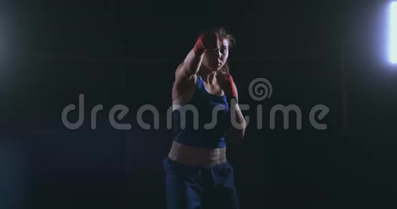 职业漂亮的女拳击手otbryvatyvat在大厅的一个黑暗的大厅里用一个影子吹着打视频的预览图