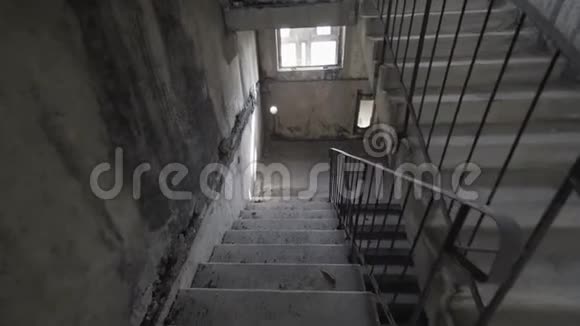 在黑暗中爬恐怖的楼梯独自在阴暗而危险的楼梯间里爬慢动作爆炸视频的预览图