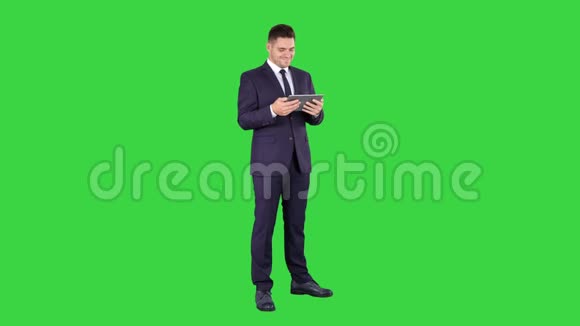 商人阅读或工作的数字平板上的绿色屏幕色度键视频的预览图