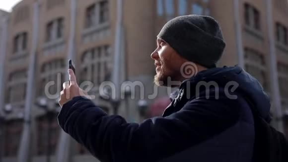 一个穿着蓝色夹克和灰色帽子的年轻人打电话给一个城市视频的预览图