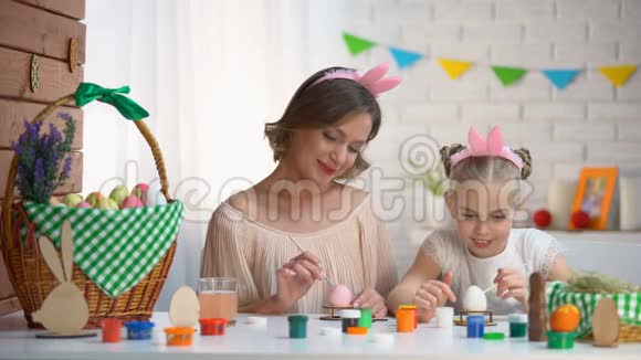 戴着可爱头巾的女儿和母亲在互相画鼻子时玩得很开心视频的预览图