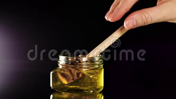 女孩拿着蜂蜜勺子等待蜂蜜和她一起流动视频的预览图