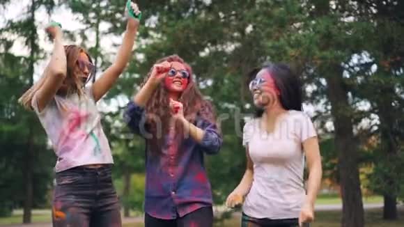 慢动作欢快的女孩多民族集体跳舞然后在公园的户外聚会上投掷油漆粉青年视频的预览图