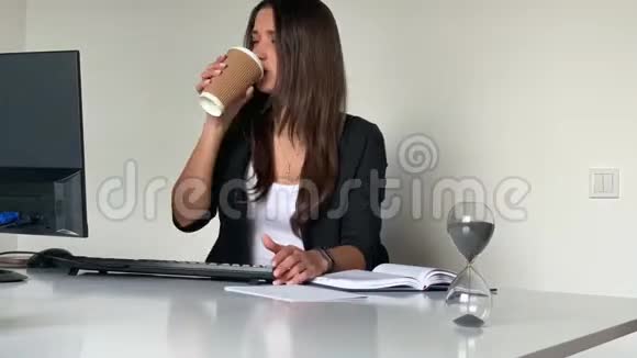女人打短信喝咖啡和客户打电话视频的预览图