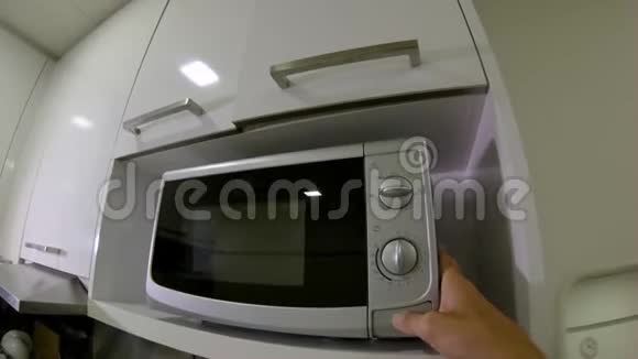 一个男人在厨房里用微波炉慢镜头视频的预览图