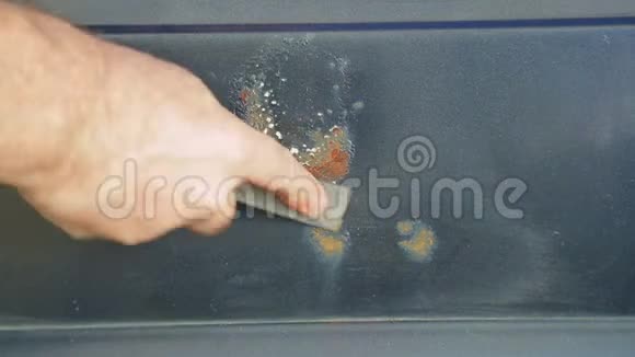 一个人用刮刀清理汽车上的铁锈时光飞逝视频的预览图