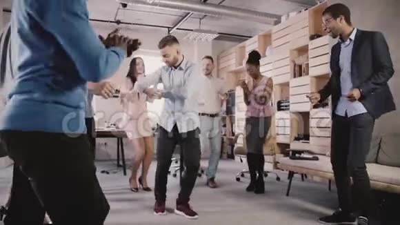 年轻的欧洲商人与同事在办公室聚会上围圈跳舞庆祝职业晋升慢动作视频的预览图