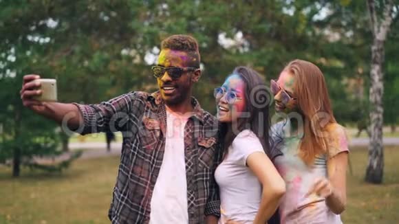 美国黑人男子戴墨镜在霍利节与漂亮女孩自拍时动作缓慢他们的脸头发视频的预览图