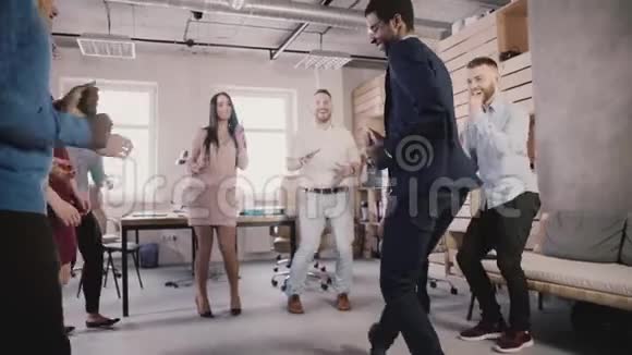 开朗多民族的商务人士在健康的办公室团队建设聚会上跳舞庆祝成功慢动作视频的预览图