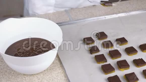 贝克手把糖果浸在融化的巧克力里巧克力糖果的生产视频的预览图
