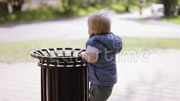 小金发男孩在公园里玩垃圾视频的预览图