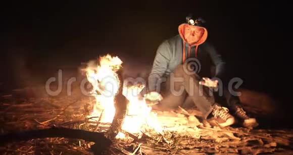 人和篝火在晚上在看火的游客视频的预览图