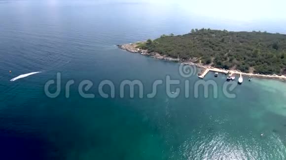 在令人惊叹的碧海中希腊的佩夫科霍里哈尔基迪基PefkohoriHalkidiki用树木和快艇进行空中观景以无人驾驶飞视频的预览图
