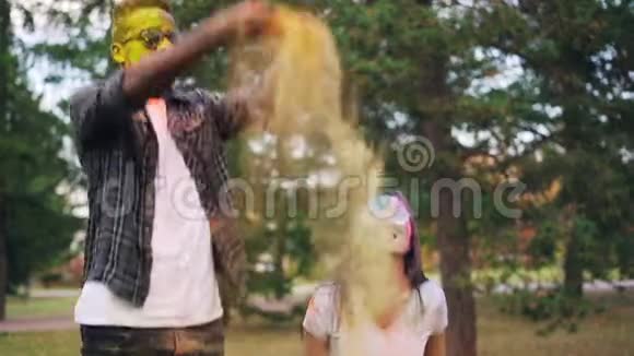 慢动作年轻人夫妇在霍利节上跳跃投掷多色油漆面粉笑着笑着视频的预览图