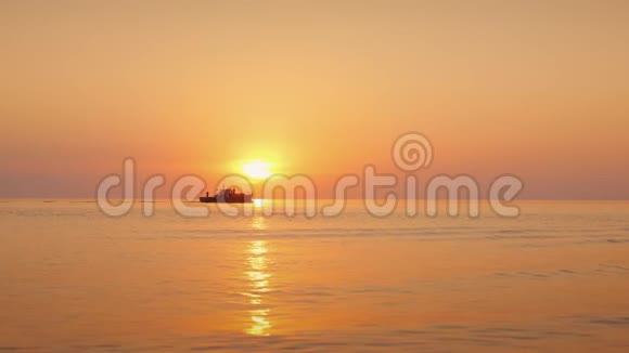 平静的海面上美丽的夕阳远处孤舟扬帆视频的预览图