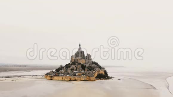 无人机上升倾斜下降到雄伟的圣米歇尔山城堡标志性的潮汐岛与修道院在诺曼底法国视频的预览图