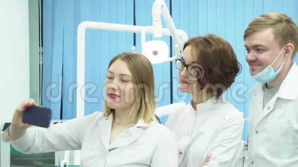 年轻医生做自拍媒体一组有吸引力的牙医在休息时根据牙科设备的背景进行自我介绍视频的预览图