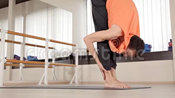 运动员男子使躯干旋转坐在地板上的健身房瑜伽练习健康生活灵活性视频的预览图