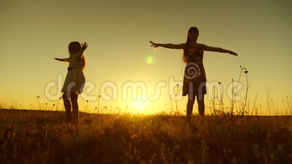 快乐的少女们在金色太阳的夕阳下旋转慢动作视频的预览图