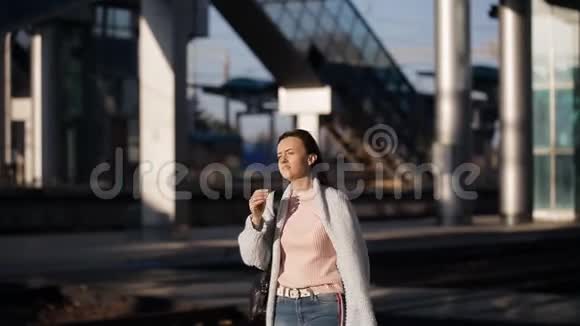 在火车站站台上最后的阳光下美丽的女人朝火车站的方向走去视频的预览图