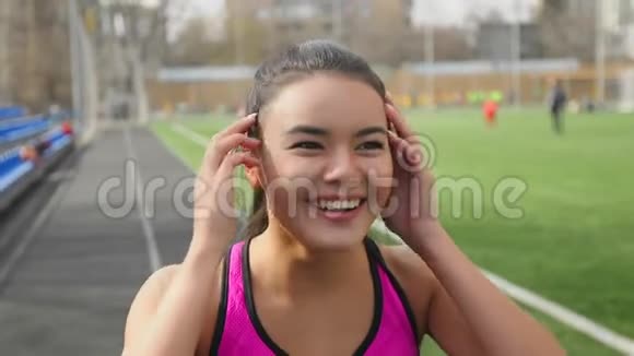开幕式前在体育场笑的亚洲跑步女孩的肖像视频的预览图