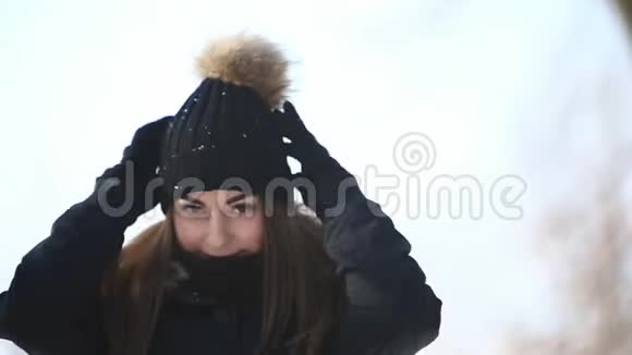 冬天美丽的年轻女子她穿着深色夹克和帽子视频的预览图