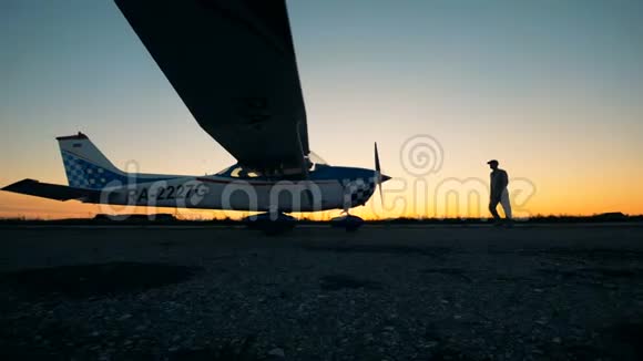 在日落背景下站在飞机附近的人小型航空概念视频的预览图