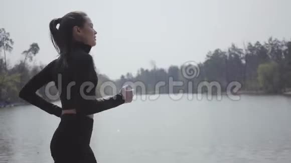 迷人的苗条女人穿着运动服在河岸上奔跑积极的生活方式运动把她的身体放进去视频的预览图