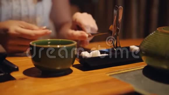 餐馆里的女人把它放进一杯茶和一片糖里视频的预览图