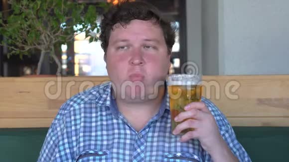 快乐的年轻人拿着一杯啤酒嚼着食物或口香糖视频的预览图