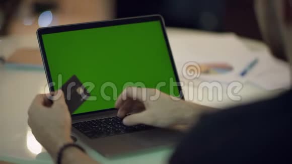男性手在手提电脑上打信用卡号码视频的预览图