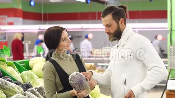 美丽的年轻微笑的夫妇一起在超市选择菜花视频的预览图