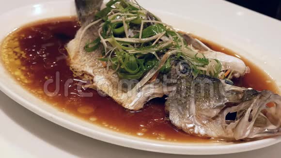蒸鲈鱼与草药和蔬菜在白菜中的运动视频的预览图