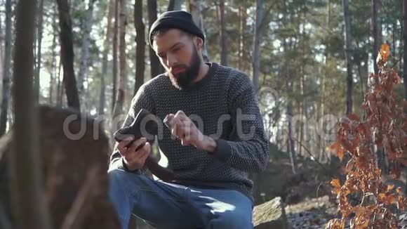 小胡子在森林里砍斧子粗鲁的男人坐在户外用斧头视频的预览图