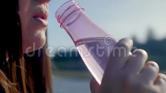 女人喝水肖像画的轮廓年轻口渴的女人长发饮水近距离射击视频的预览图